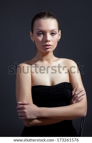 Charming slim model posing in black cocktail dress
