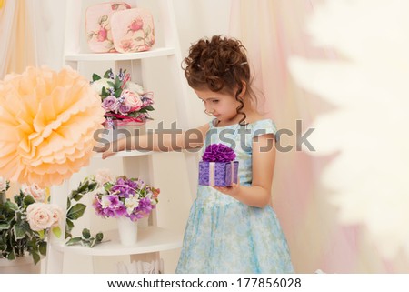 Beautiful girl posing in smart dress with gift box