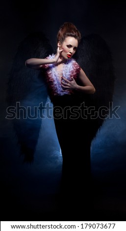 Bloodthirsty girl - fallen angel posing at camera