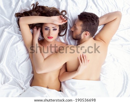 Image of weary young lovers lying on silk sheets