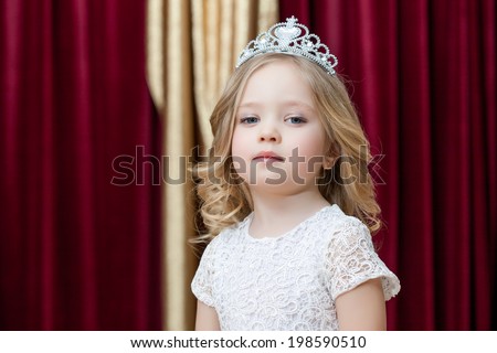 Majestic girl posing in smart dress and tiara