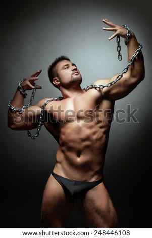 Handsome muscled male dancer breaking chain