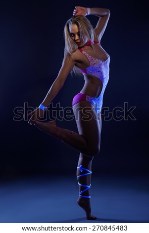 Go-go showgirl posing at camera in UV light