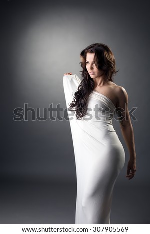 Seductive brunette posing in loose-fitting dress