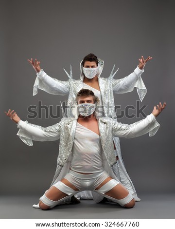 Sexy male dancers in bright costumes and masks