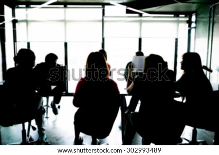 Silhouettes of Business People Having Board Meeting. Blur or Defocus image.
