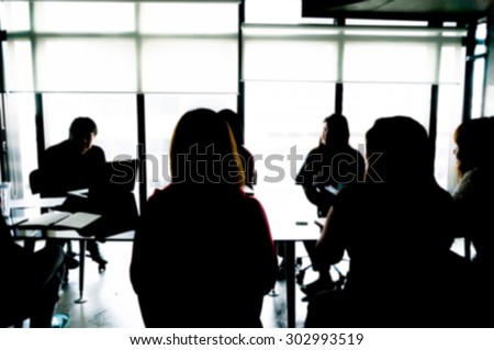 Silhouettes of Business People Having Board Meeting. Blur or Defocus image.