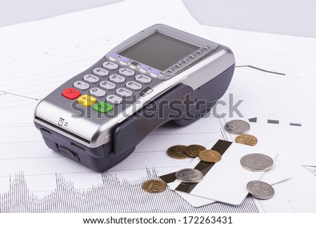 Business still-life of a payment terminal, cards, money, coins