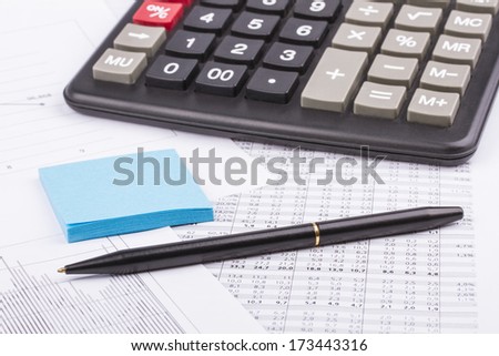 Business still-life of a blue pen, stickers, graph, calculator