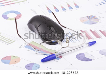 Business still-life of a pen, eyeglasses, computer mouse