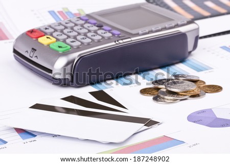 Business still-life of a payment terminal, cards, money, coins