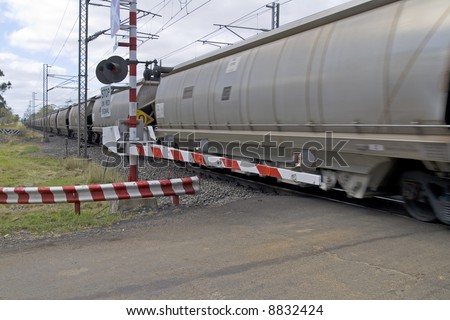 Freight train passing a railroad crossing with gates