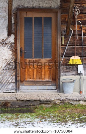 House cleaning utilities on a wooden facade besides a door