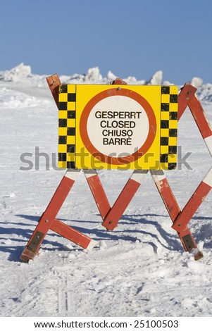 A road barrier blocks a ski slope from access