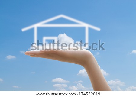 House in  hands against the blue sky