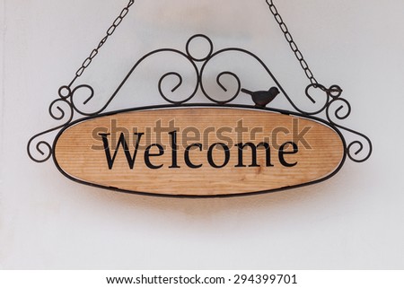 wood welcome sign hanging on wall of restaurant