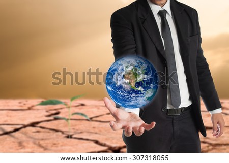 Businessman holds Earth in a hand , global warming concept.\
Elements of this image are furnished by NASA