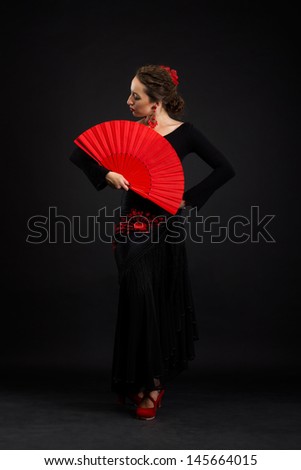 Flamenco dancer in black dress with red fan