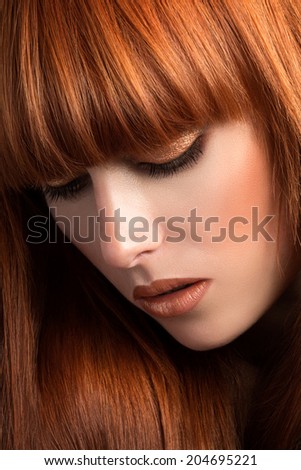 Beautiful red haired woman looking down (sensual look)