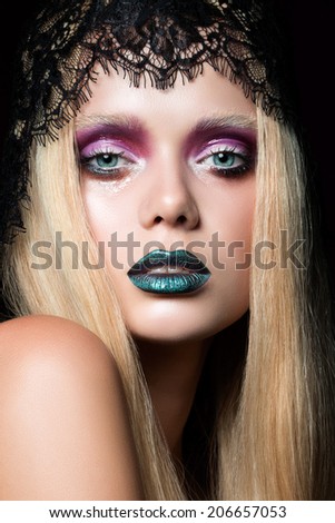 Fashion portrait of young woman with blue lips and wet eyelid effect stage make-up