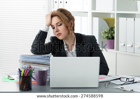 Tired stressed business woman sitting with huge pile of papers