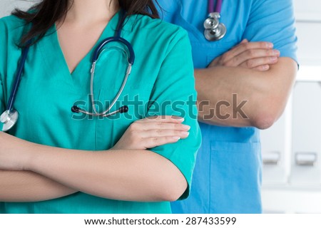 Two doctors standing with their arms crossed on chest ready to work. Healthcare and medical concept.