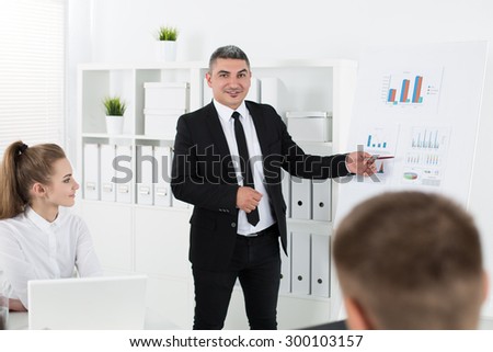 Business people meeting in office to discuss project. Adult businessman pointing to diagram. Business success and teamwork concept