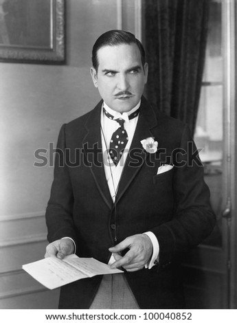 Man in a morning suit pointing at a piece of paper