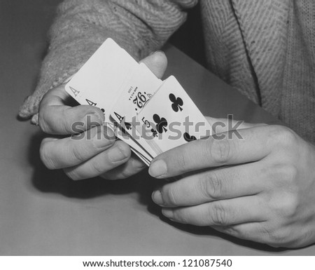 Close-up of man\'s hands shuffling playing cards