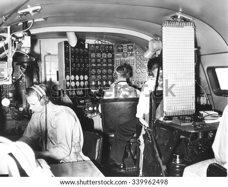 In the cabin of the 82-ton Douglas B-19, the world's largest bomber. Nov. 13, 1941. L-R: the radioman, the flight engineer at the complex 'dashboard,' and a representative from the Wright Duplex Photo stock © 