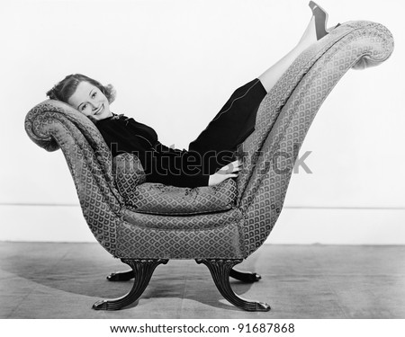 Portrait of woman on curved piece of furniture