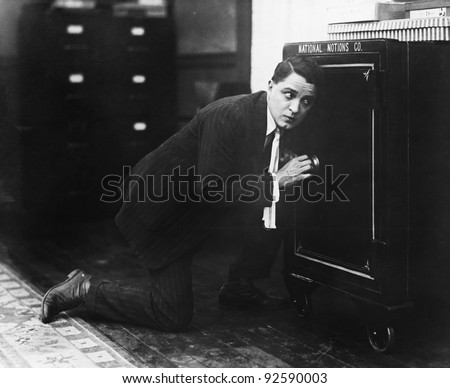 Profile of a man opening the door of a safe