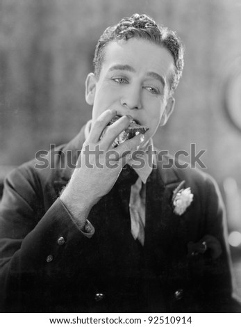 Man with a piece of cake in his mouth