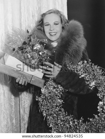 Portrait of woman with Christmas wreath and gifts