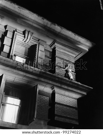 Woman standing on the top of a building on a ledge