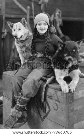 Woman posing with two sled dogs