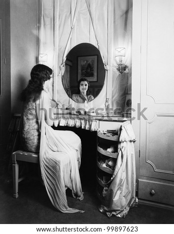 Woman looking in mirror at dressing table