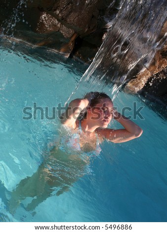 Woman under Waterfall in Spa Atmosphere