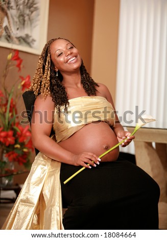 Gorgeous and Glowing African American woman eight Months Pregnant and Laughing