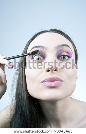 Funny girl applying mascara
