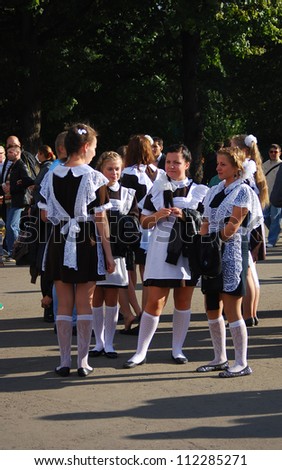 MOSCOW, RUSSIA - SEPTEMBER 01: Young ladies, age about 17, wearing soviet school uniform walking in Gorky park in conjunction with Moscow 865th birthday on September 01, 2012 in Moscow, Russia.