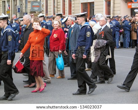 SAINT-PETERSBURG, RUSSIA - MAY 09: Woman in red is sending a kiss. Victory Day celebration on the Nevsky prospect. Military parade. Taken on May 09, 2008 in Saint-Petersburg, Russia.