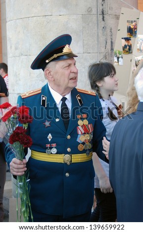 MOSCOW, RUSSIA - MAY 09: A war veteran holds flowers. Victory Day celebration in the Gorky park on May 09, 2013 in Moscow.