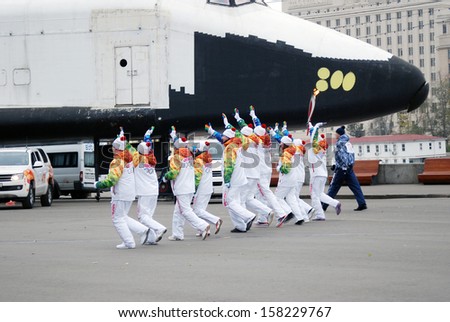 MOSCOW - OCTOBER 07: Torchbearers of the Olympic flame run along the Moscow river in the Gorki recreation park on October 07, 2013 in Moscow. They participate in the relay of the Olympic Flame.