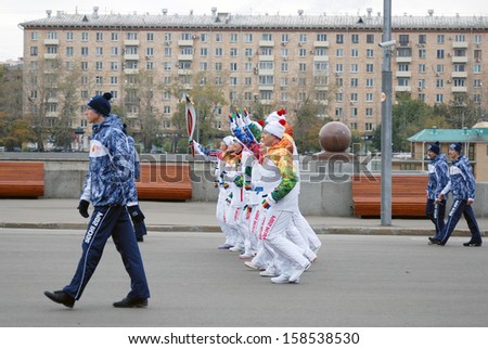 MOSCOW - OCTOBER 07: Torchbearers of the Olympic flame run along the Moscow river in the Gorki recreation park. They participate in the relay of the Olympic Flame on October 07, 2013 in Moscow.