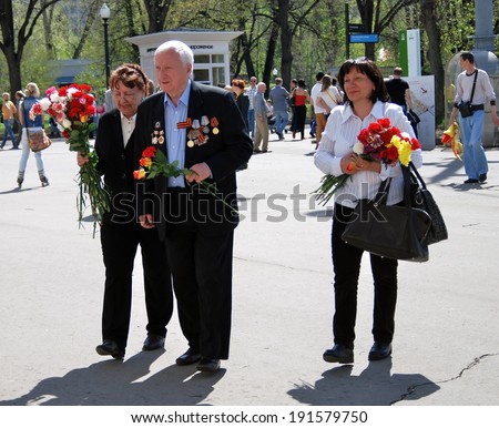 MOSCOW, RUSSIA - MAY 09: A war veteran holding flowers. Victory Day celebration in the Gorky park on May 09, 2013 in Moscow.