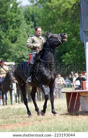 MOSCOW - JUNE 08, 2014: Horse riders competition. A rider is dressed in vintage military uniform. Times and Ages International Historical Festival in Kolomenskoye, Moscow.
