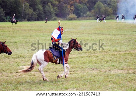 MOSCOW REGION - SEPTEMBER 07, 2014: Reenactor dressed as Napoleonic war soldier rides a horse at Borodino battle historical reenactment.