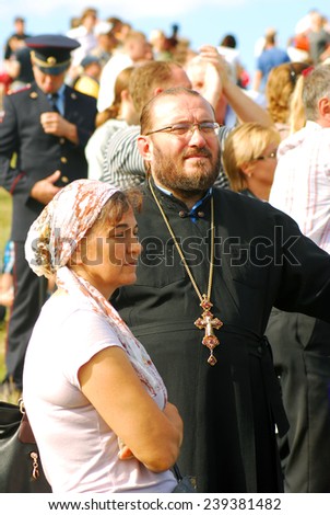 MOSCOW REGION - SEPTEMBER 07, 2014: Priest man and a woman watch Borodino battle historical reenactment.