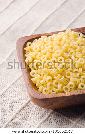 Small pasta rings in a wood bowl.